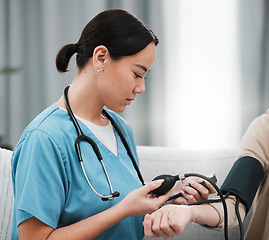 Image showing Blood pressure, Asian nurse and patient in a nursing home sofa for health and wellness check. Healthcare, doctor and living room consultation for medical test in retirement on a lounge couch