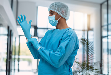 Image showing Surgeon, doctor with gloves and surgery with face mask and health, man in ppe for safety, operation and ready for procedure. Cardiovascular, clean scrubs and person in clinic with male physician