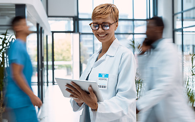 Image showing Tablet, doctor and black woman in busy hospital or clinic for research, telehealth or online consultation. Healthcare app, technology and smile of happy senior medical professional with touchscreen.