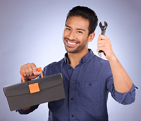 Image showing Portrait, tool and Asian man with box, smile and maintenance with guy against blue studio background. Face, male employee and handyman with happiness, equipment and contractor with service and happy