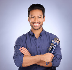 Image showing Man, studio and portrait with tools or wrench for handyman, maintenance or repair work with smile. Happy asian model person on blue background with spanner for engineer, mechanic or technician job