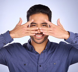 Image showing Hiding, funny and portrait of an Asian man with a hand isolated on a studio background. Comic, crazy and Japanese person covering the face for humor, shy expression and gesture on a backdrop