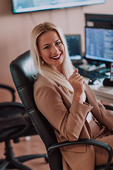 Image showing A businesswoman sitting in a programmer's office surrounded by computers, showing her expertise and dedication to technology.