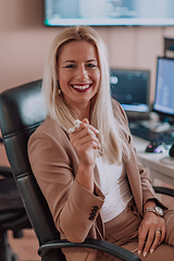 Image showing A businesswoman sitting in a programmer's office surrounded by computers, showing her expertise and dedication to technology.