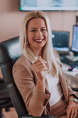 Image showing A businesswoman sitting in a programmer's office surrounded by computers, showing her expertise and dedication to technology.