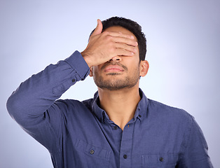 Image showing Hand, face and regret with a man in studio on a gray background feeling disappointed by a mistake. Facepalm, problem and frustrated with a male covering his eyes while annoyed, upset or ashamed