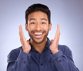 Image showing Portrait, wow and Asian man with smile, surprise and excited with happy guy against blue studio background. Face, male and gentleman with happiness, shocked for good news, success and announcement