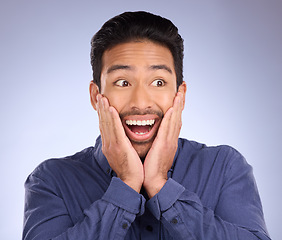 Image showing Face, wow and surprise with a man in studio on a gray background looking shocked at an announcement. Hands, notification and omg with a handsome young male feeling surprised or in awe at good news