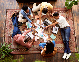 Image showing Teamwork, creative and overhead with a designer team lying on the floor while working on a project. Collaboration, startup or ideas with a group of young people working in advertising or marketing