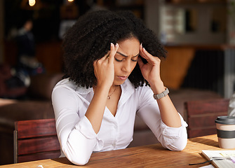 Image showing Business stress, headache and black woman in coffee shop feeling pain, migraine or tired. Mental health, anxiety and remote worker or female employee with depression, burnout or fatigue in restaurant
