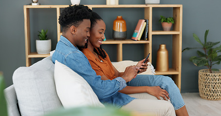 Image showing Internet, technology and couple with phone on sofa in living room. Black man teaching young woman how to use banking app, online shopping or fintech on a smartphone, while sitting on a couch at home.