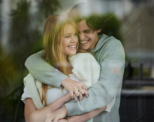 Image showing Couple hug, happiness with smile by window and love with young people, partnership and holding hands with trust. Commitment, relationship and care with happy man and woman are content with joy