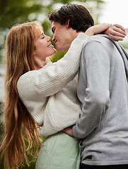 Image showing Couple kiss outdoor, hug with love and commitment in relationship, trust and care with gen z man and woman in park. Travel, happiness and partnership, romance and content with young people together