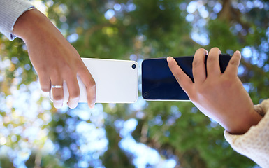 Image showing Hands, phone and networking with people sharing data or information outdoor in a park from below. Contact, bluetooth and 5g mobile technology with friends outside to share media on a wireless network