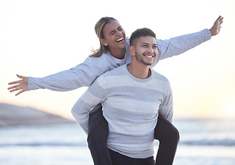 Image showing Couple, piggyback and laughing at beach for love, care and happy outdoor date together. Man carrying fun woman at sea, freedom and support of trust, relax and vacation for happiness, travel and smile