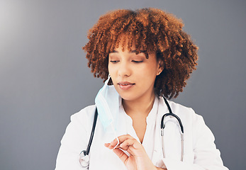 Image showing Black woman, doctor and covid 19, remove face mask and health, end of pandemic and protection on studio background. Serious, mockup space with healthcare, safety and post coronavirus with female