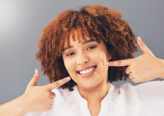 Image showing Portrait, teeth and black woman pointing, excited and dental hygiene against grey studio background. Face, Jamaican female and girl with smile, oral health and gesture to dimples, mouth and wellness