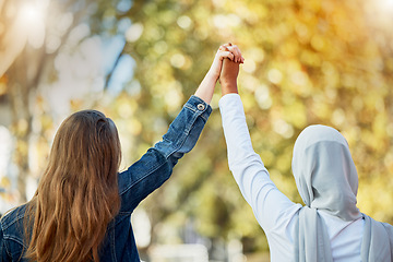 Image showing Support, love and women holding hands for unity, trust and solidarity in nature while on a walk. Freedom, multicultural and female friends with an affection gesture while walking in a park or garden.