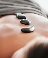 Image showing Woman, rocks and back in spa relaxation for treatment, stress relief or massage at resort. Female relaxing with hot stone in physical therapy for skincare, body healing or zen wellness at salon