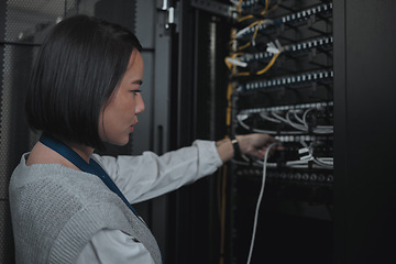 Image showing Asian woman, technician and server room for cabling, networking or system maintenance at office. Female engineer plugging wire for cable service, power or data security in admin or network management