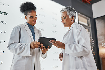 Image showing Tablet, optometrist teamwork and women in shop talking, research or discussing eye test results. Vision, touchscreen technology and senior optician with black woman at glasses store for telehealth.