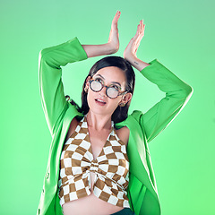 Image showing Gen z, queen and woman with hand crown isolated on a green background in a studio. Thinking, royal and girl model with a trendy idea, arrogant expression and edgy with a gesture on a backdrop