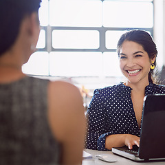 Image showing Coworking, happy and business women talking for a meeting, interview or planning together. Smile, conversation and employees speaking, laughing and communicating about work while typing on a laptop