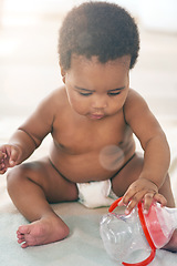 Image showing Children, black baby and girl with a bottle sitting on a blanket on the floor of a home for child development. Kids, cute and curious with a newborn infant learning or growing alone in a house