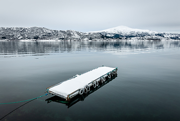 Image showing snowy floating jetty on clear sea