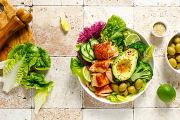 Image showing Salmon avocado bowl with broccoli, olives and fresh salad. Healthy food, keto diet, top view