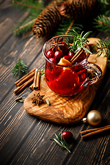 Image showing Christmas mulled wine with cranberry, orange, cinnamon, anise and rosemary. Traditional hot drink or beverage, festive Xmas or New Year winter cocktail
