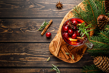 Image showing Christmas mulled wine with cranberry, orange, cinnamon, anise and rosemary. Traditional hot drink or beverage, festive Xmas or New Year winter cocktail