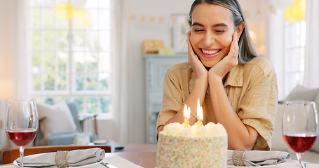 Image showing Couple, birthday and cake with kiss, blowing candles and hug, smile and clapping at a party in home. Happy latino man and woman with celebration, surprise and gift with romance, love and happiness