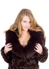 Image showing The young beautiful woman in a fur coat over white