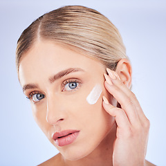 Image showing Skincare, face portrait and woman with cream in studio isolated on a blue background. Dermatology closeup, beauty cosmetics and young female model apply hydration lotion, creme or moisturizer product