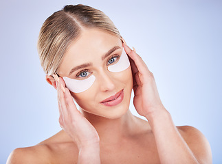 Image showing Face portrait, skincare and woman with eye mask in studio isolated on a blue background. Dermatology, makeup cosmetics and beauty of female model with facial patches for healthy skin or collagen.