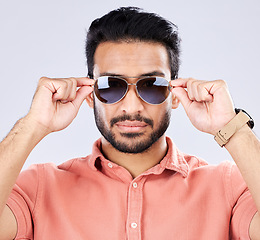 Image showing Portrait, sunglasses and man with fashion, trendy and casual clothes against grey studio background. Face, male or gentleman with eyewear, cool or edgy with style, confidence or carefree with success