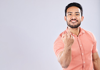 Image showing Angry, rude and portrait of an Asian man with a middle finger isolated on a grey studio background. Mockup, space and Japanese guy with a mean, bad and negative hand gesture for anger and aggression