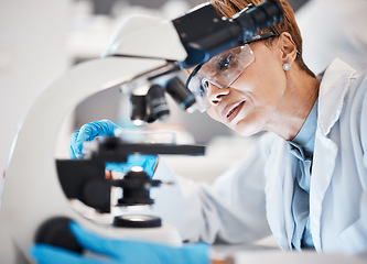 Image showing Medical science, woman and microscope in a laboratory for research, analytics and to study particle. Scientist person with glasses for dna or bacteria in lab for innovation, future and biotechnology