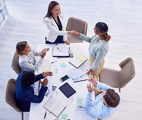 Image showing Handshake, applause and an overhead meeting in a boardroom for celebration of an achievement or promotion. Thank you, welcome or greeting with business women shaking hands in agreement at the office