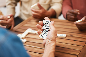 Image showing Hands, dominoes and friends in board games on wooden table for fun activity, social bonding or gathering. Hand of domino player holding rectangle number blocks playing with group for entertainment