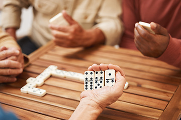 Image showing Hands, dominoes and friends in board games on wooden table for fun activity, social bonding or gathering. Hand of domino player holding rectangle number blocks playing with group for entertainment