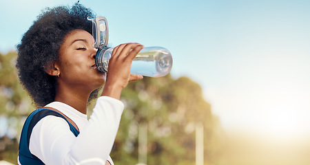 Image showing Sports, black woman and drinking water at field for training, exercise or match against mockup. Hydration, fitness and thirsty athletic girl relax with drink during workout, practice or outdoor game