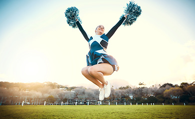 Image showing Sports woman, sky and cheerleader jump with energy to celebrate goal outdoor. Cheerleading or athlete person dance in nature with pompoms for performance, game or competition on a green grass field