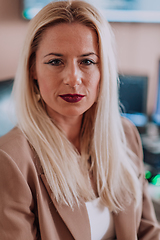 Image showing A businesswoman sitting in a programmer's office surrounded by computers, showing her expertise and dedication to technology.