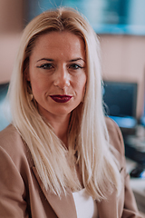 Image showing A businesswoman sitting in a programmer's office surrounded by computers, showing her expertise and dedication to technology.