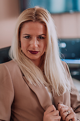 Image showing A businesswoman sitting in a programmer's office surrounded by computers, showing her expertise and dedication to technology.