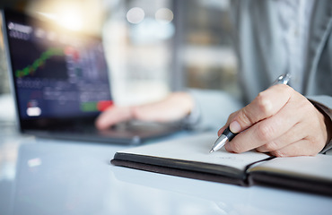 Image showing Trader, hands and writing notes in book by laptop on stock market chart or graph statistics for trading at the office. Hand of investor or broker taking note of bitcoin, cryptocurrency or investment