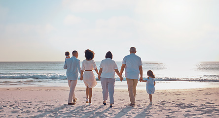 Image showing Grandparents, parents and children walking on beach for holiday, vacation and weekend by sea. Travel, sunset and kids holding hands with big family for adventure, journey and relax for bond together