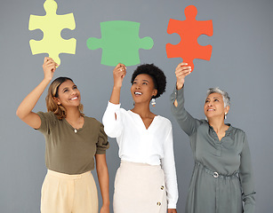 Image showing Business people, puzzle pieces and synergy, connection and smile with diversity on studio background. Problem solving, link and working together with teamwork and cooperation with women in corporate